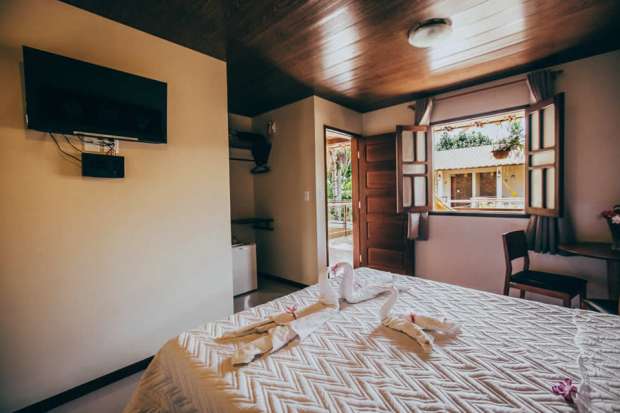 Quarto com TV, banheiro privativo e camas boxe